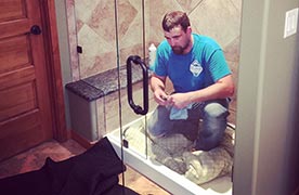 person installing new shower glass