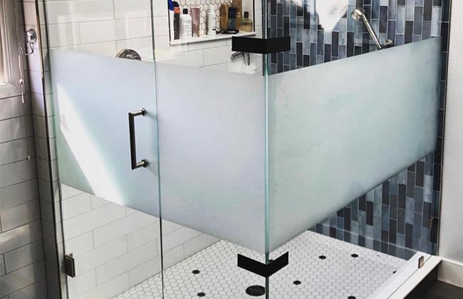 a frameless shower enclosure with a privacy band