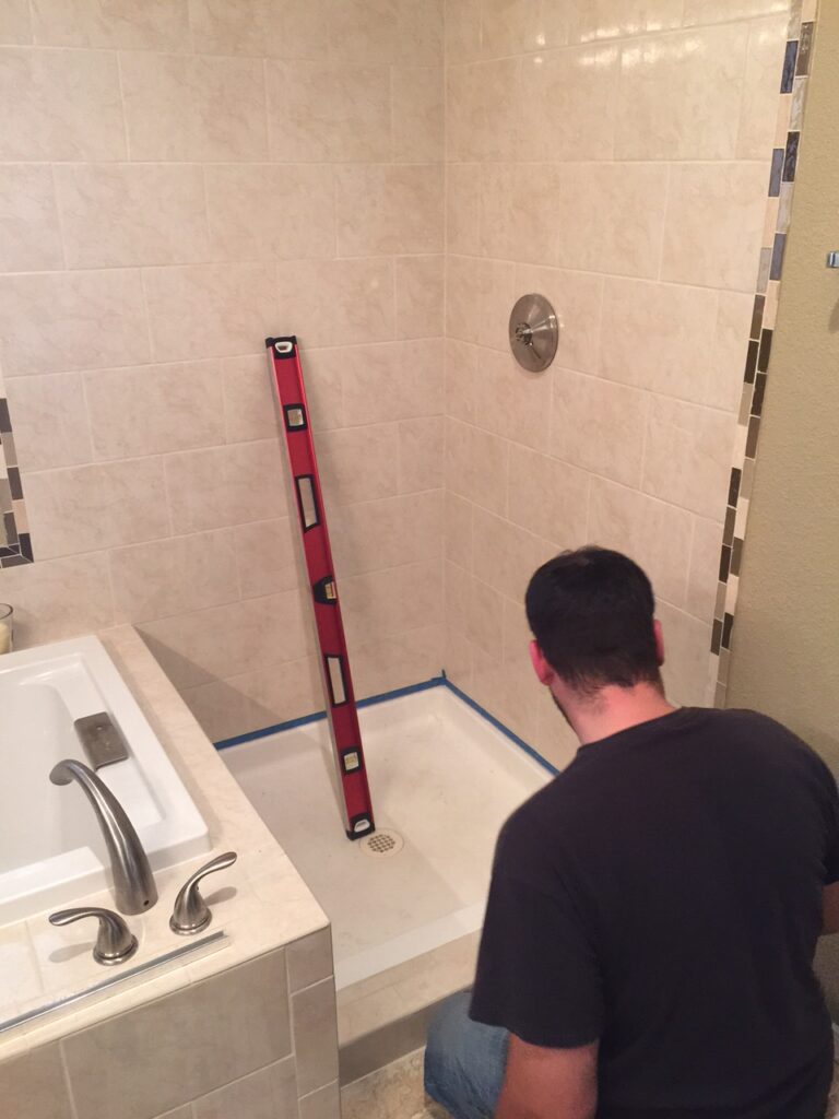 Making some marks for the glass to line up on, for this 3-panel shower enclosure in aurora colorado